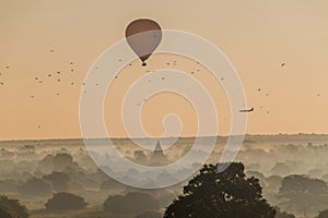 Balloon over Bagan, landing airplane and the skyline of its temples, Myanm