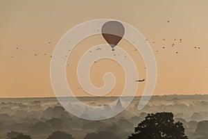 Balloon over Bagan, landing airplane and the skyline of its temples, Myanm