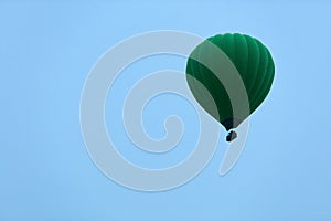 Ballooning. Green Hot Air Balloon Flying High In Blue Sky