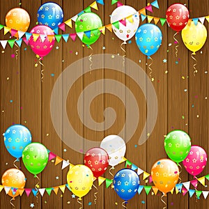 Balloons and confetti on brown wooden background