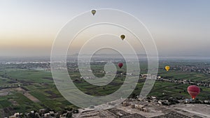 Balloons fly over the Nile Valley at dawn.
