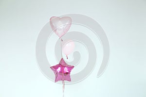 Balloons in the form of a heart and a star in pink colors on a white background.