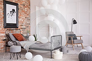 Balloons in industrial stylish bedroom, real photo with copy space