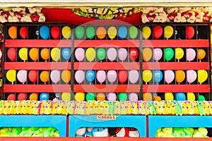 Balloons and prizes at a dart throwing game booth at a carnival, fair, or amusement park