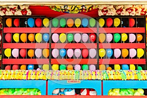 Balloons and prizes at a dart throwing game booth at a carnival, fair, or amusement park photo