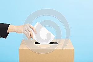 Ballot box with person casting vote on blank voting slip photo