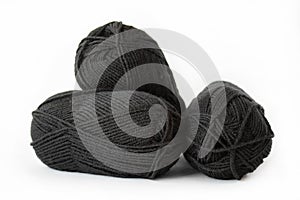 Balls of black plain yarn on white background.