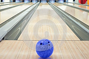 Balls on bowling alley against ten pins