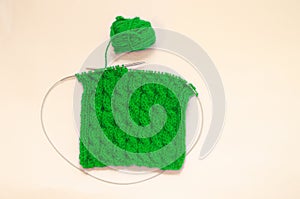 Balls of colored knitting threads and knitting needles on a white background