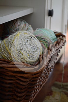 Balls of colorful yarn in brown wicker basket