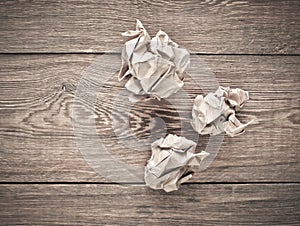 Balls of crumpled old paper on a wooden table. The concept of inappropriate, spent ideas