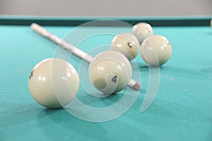 Balls and a cue for Russian Billiards on a billiard table with a green cloth