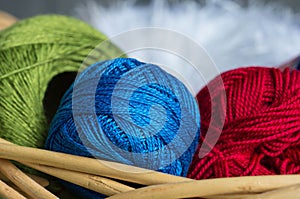 Balls of a green, blue and red yarn in a basket