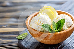 Balls of lemon ice cream in a wooden bowl.