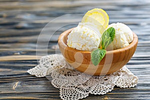 Balls of lemon ice cream in a wooden bowl.