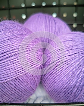 Balls of lilac yarn closeup. The texture of  threads for knitting. Yarn purple violet background