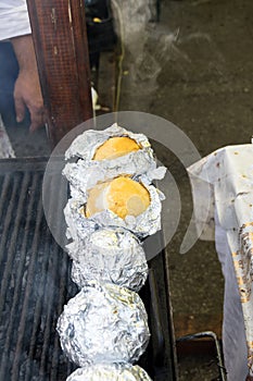 Balls of polenta and cheese in the middle of it, named bulz, a traditional romanian dish. Roasting polenta and cheese on a grill
