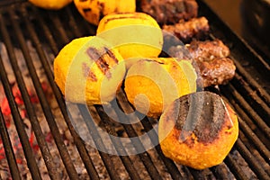 Balls of polenta named bulz with cheese in the middle of it cooked on a grill.