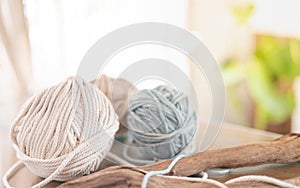 Balls of white and beige yarn on light wood table. Threads of high quality wool for macrame and handicrafts