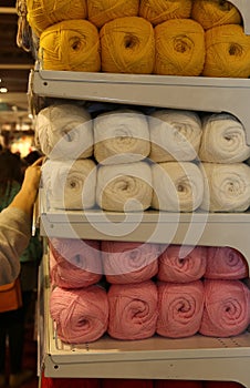 Balls of wool on the store shelf for hobbyists and seamstresses