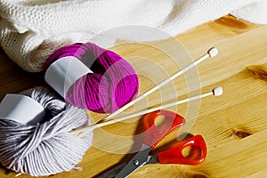 Balls of wool and wooden knitting needles on the table.