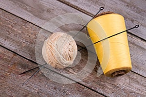 Balls of yarn with knitting needles on a wooden background.