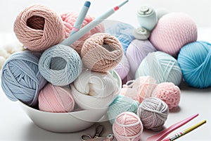 Balls of yarn in light pastel colors in knited backet. Skeins of yarn, needles and tools for needlework