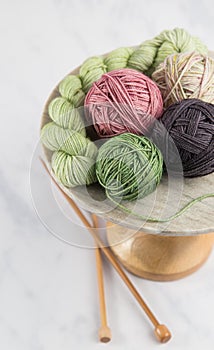 Balls of yarn on stand with knitting needles