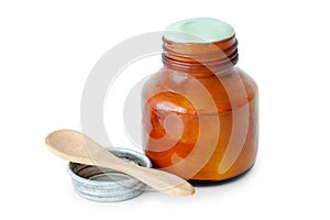 A balm jar full of medicated ointment and spoon.