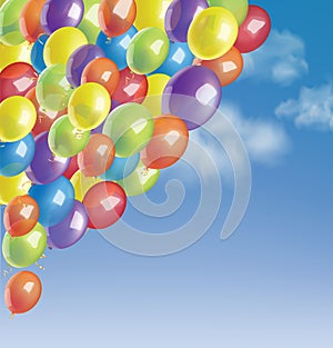 Baloons in a blue sky with clouds.