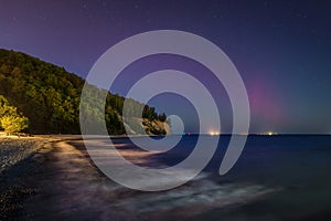 Baltic cliff in Gdynia Orlowoat night with Northerm lights over the sea. Poland photo