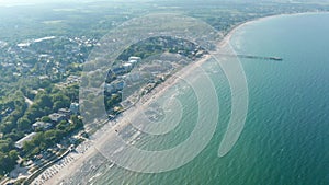 Baltic sea aerial drone view, tourist beach summertime destination in Scharbeutz, Germany, tilt down to coast, day