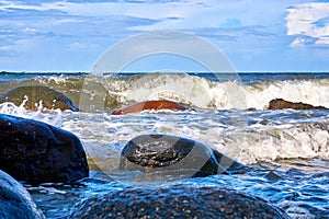 Baltic Sea with big stones and foaming waves on the shore