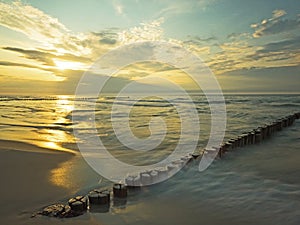 Baltic Sea with breakwaters at sunset