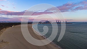 Baltic Sea and the Stogi beach in sunrise colors with DCT terminal, Gdansk. Poland.