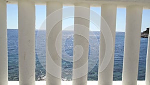 Baluster beach. White columns overlooking the sea. View of white pillars and horizont on blue sea and the sky in the background.