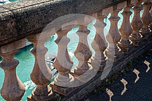 Balustrade wall looking down the the water in the harbour and a boat passing by