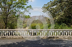 Balustraded road bridge in verdant city at sunny spring noon