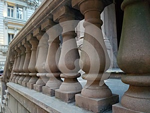 Balustrades made of brown stone in a row at brownstone entrance.