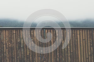 bamboo banister with view of fog & cloud on mountain in morning.