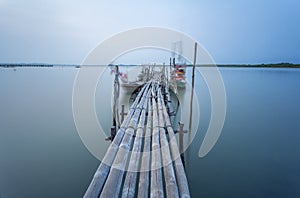 Bamboo bridge and moving fishing boat using long exposure techn