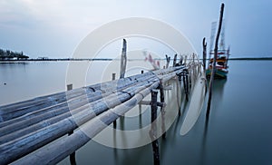 Bamboo bridge and moving fishing boat using long exposure techn