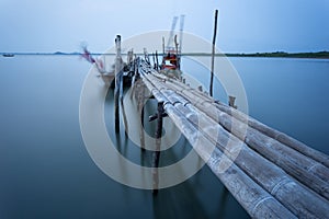 Bamboo bridge and moving fishing boat using long exposure techn