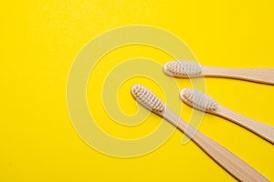 Bamboo brush on a yellow background. No plastic. Ecology. Taking care of the world around you. Toothbrush. Clean teeth. Yellow