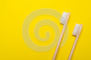 Bamboo brush on a yellow background. No plastic. Ecology. Taking care of the world around you. Toothbrush. Clean teeth. Yellow