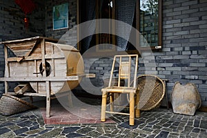 Bamboo chair and wooden thresher outside farmhouse