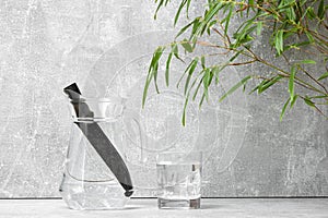 Bamboo charcoal water filter stick, green leaf and glass of water. Natural bamboo charcoal is a powerful purifier which refreshes