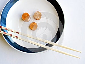 Bamboo chopsticks, plate, and pennies