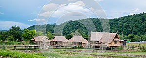 The bamboo cottage, the simple lifestyle of a Thai farmer with a mountainous background below the blue sky at Thailand