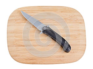 Bamboo cutting board with a knife.